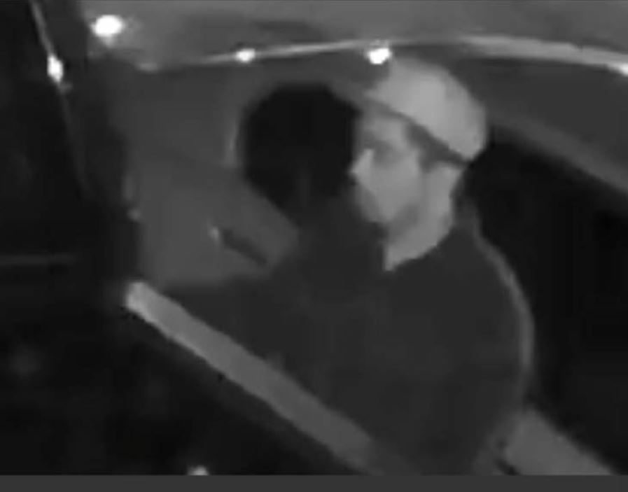 Black and white photo of suspect wearing light colored cap and dark colored sweatshirt.